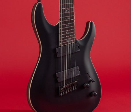 Close-up on the strings of a Schecter 7-string guitar on a red background