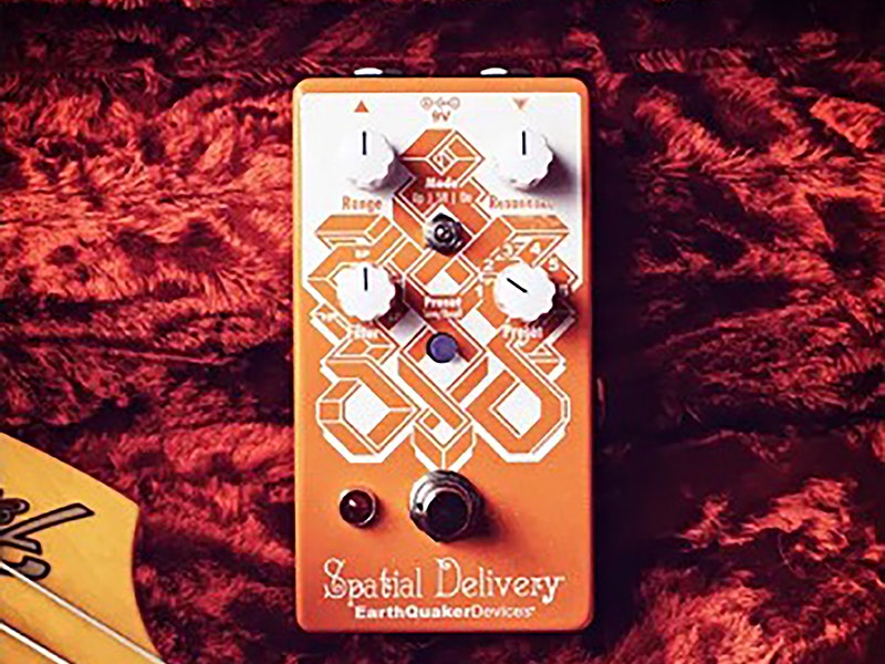 EarthQuaker Devices Spatial Delivery envelope filter guitar pedal in orange with white knobs and geometric artwork on a red carpet