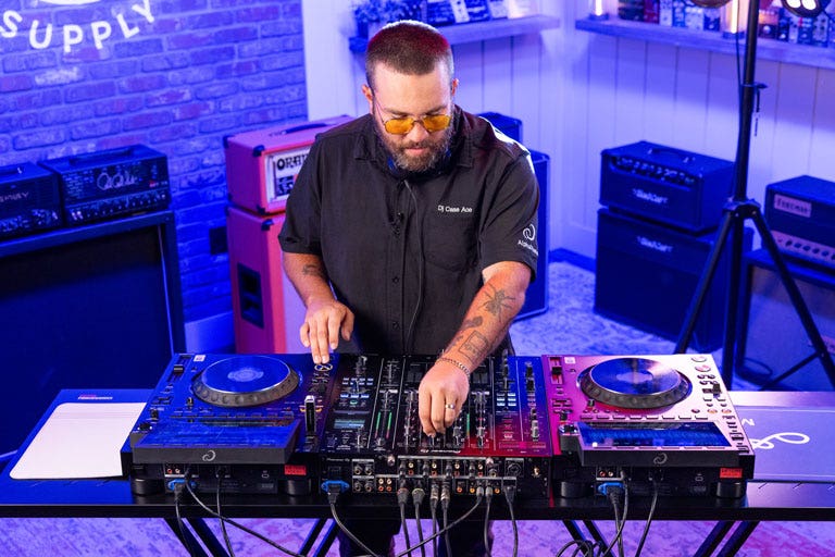 DJ Case Ace adjusting the levels on a Pioneer DJ mixer