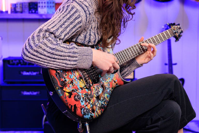 Photo of a guitarist playing a PRS baritone electric guitar in the AMS studio