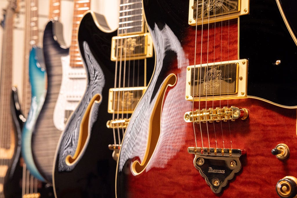 Photo of semi-hollow body guitars hanging on a wall