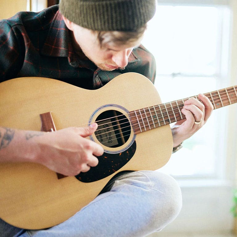 Photo of a guitarist playing a Martin concert acoustic guitar