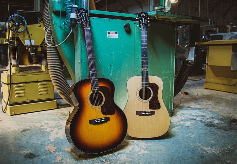 Photo of two Guild jumbo acoustic guitars in a factory