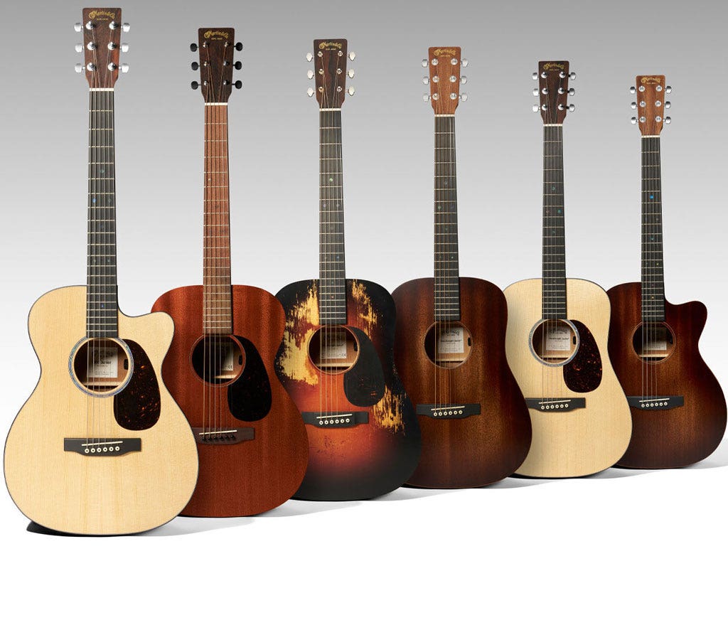 A wide variety of small acoustic guitars on a white background