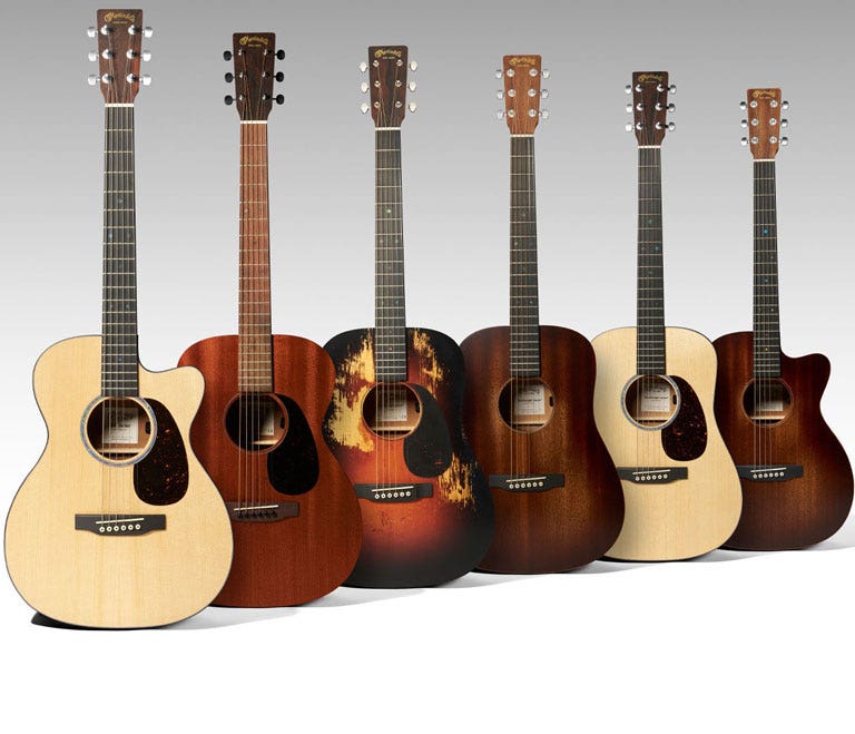 A wide variety of small acoustic guitars on a white background