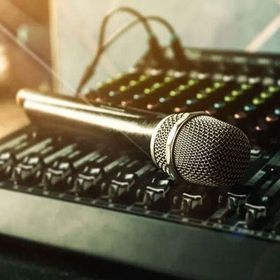 A microphone sitting on a mixer.