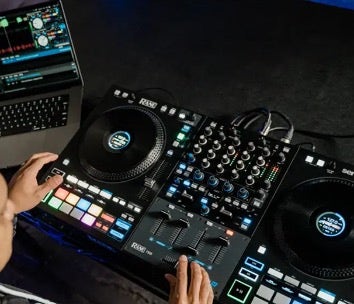 A person operates a DJ controller next to a laptop.
