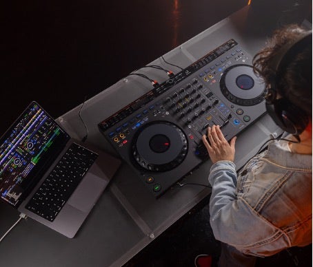Alt tag: A DJ wearing headphones uses a mixing board