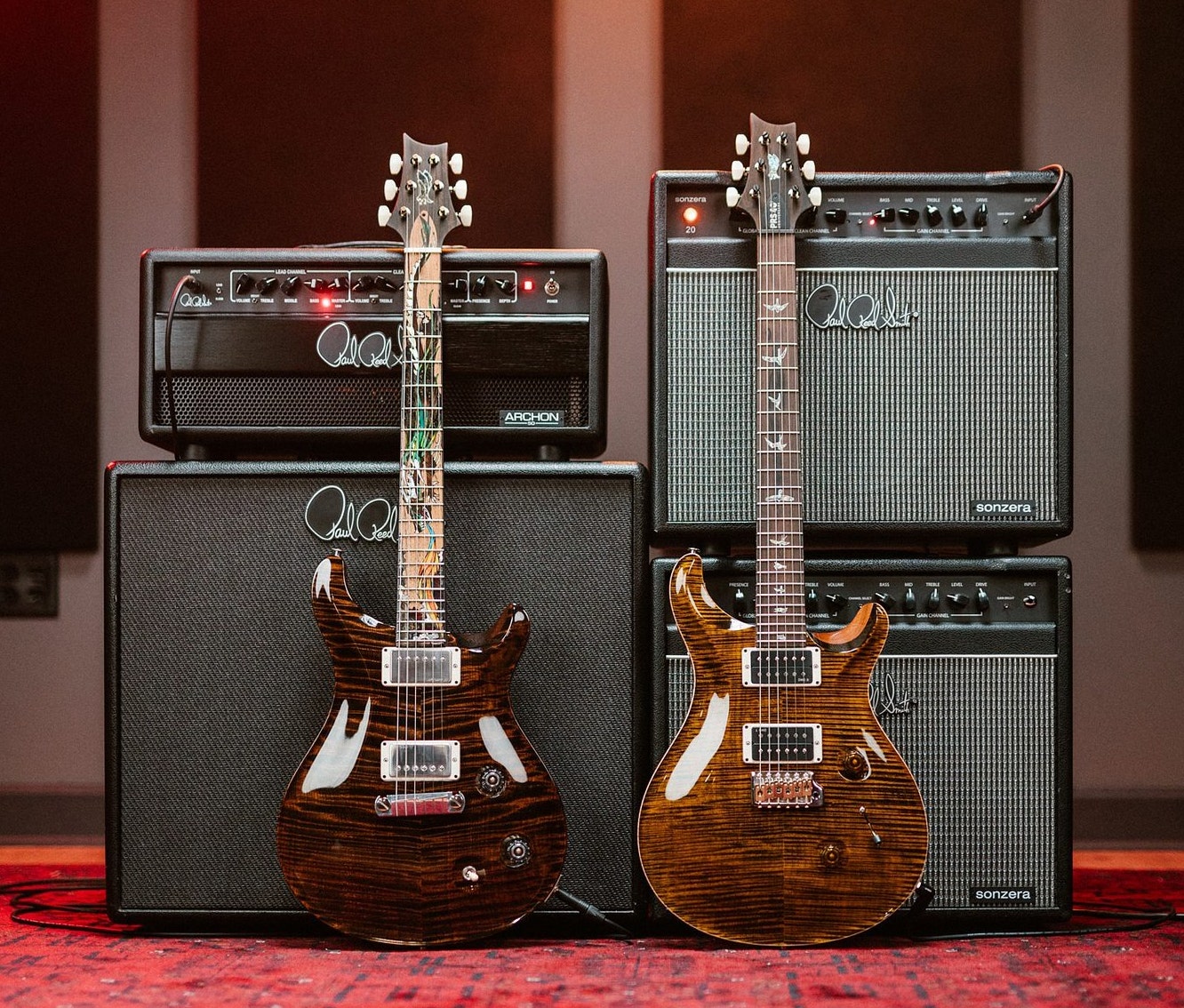 PRS Electric guitars leaning against various PRS guitar amps