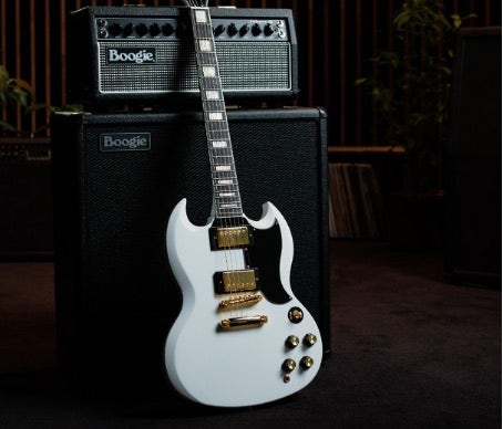 White Epiphone SG guitar resting upright on an amp