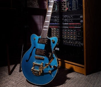 Blue Gretsch guitar resting against a studio rack.