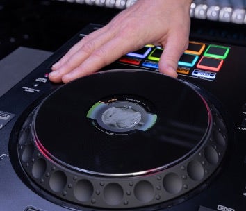A close-up shot of a hand adjusting the jog wheel on a DJ turntable mixer.