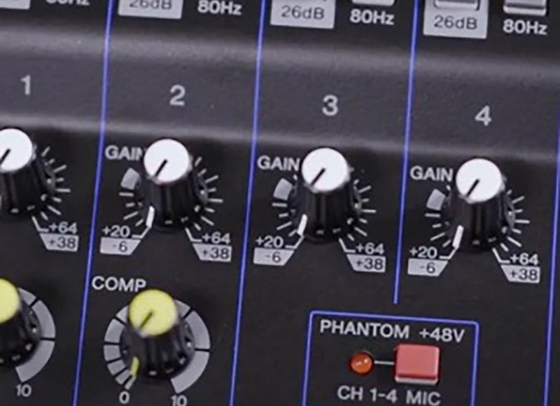 Close-up of a live sound mixer's gain and compression knobs.