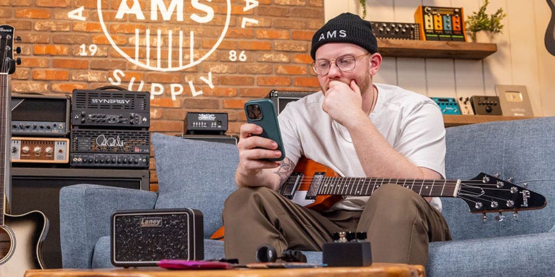 Photo of a musician browsing for gear on his phone
